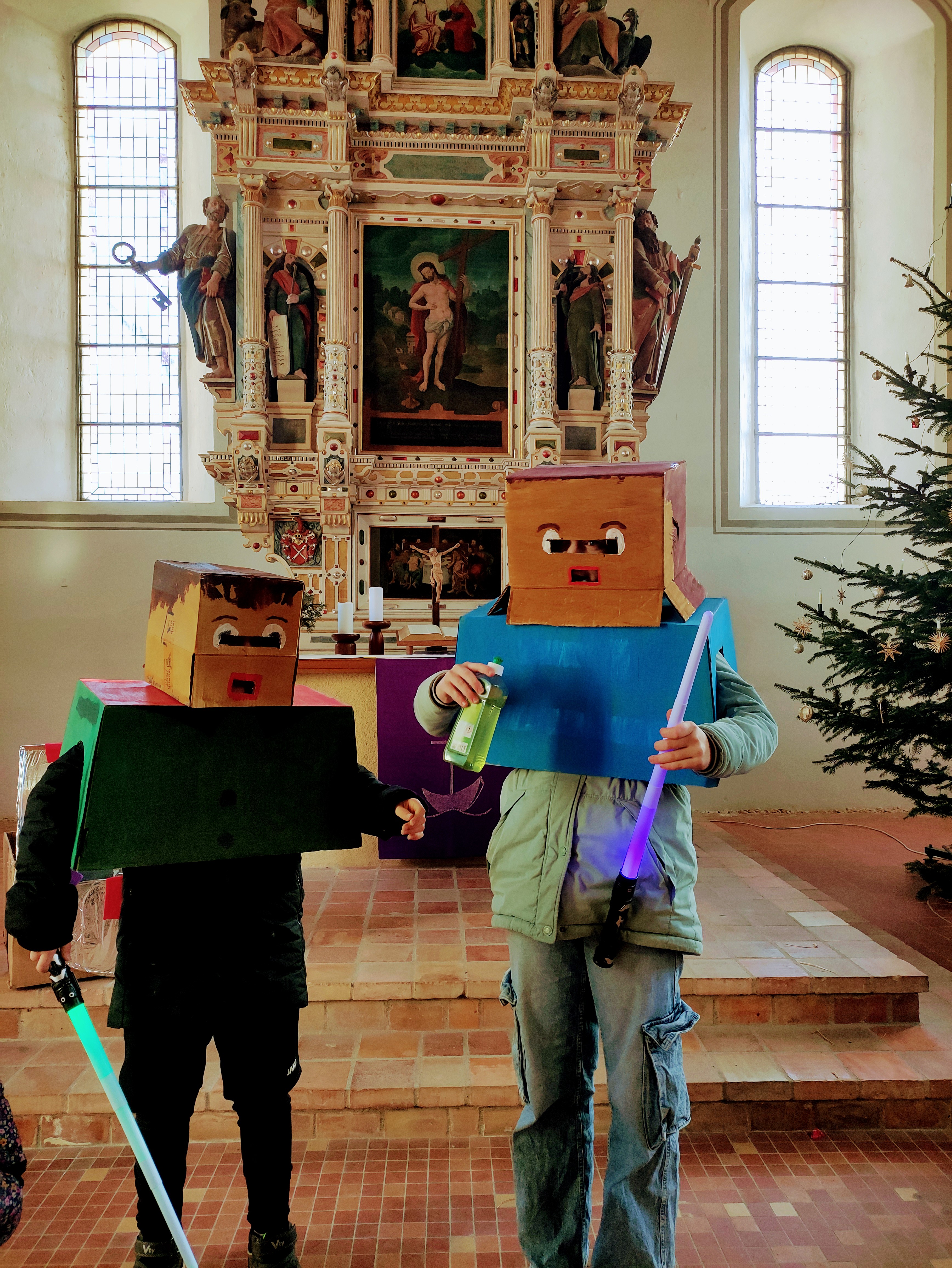 Nahaufnahme eines Babys mit weißem Oberteil. Im Hintergrund unscharf eine Frau mit dunklen Haaren.