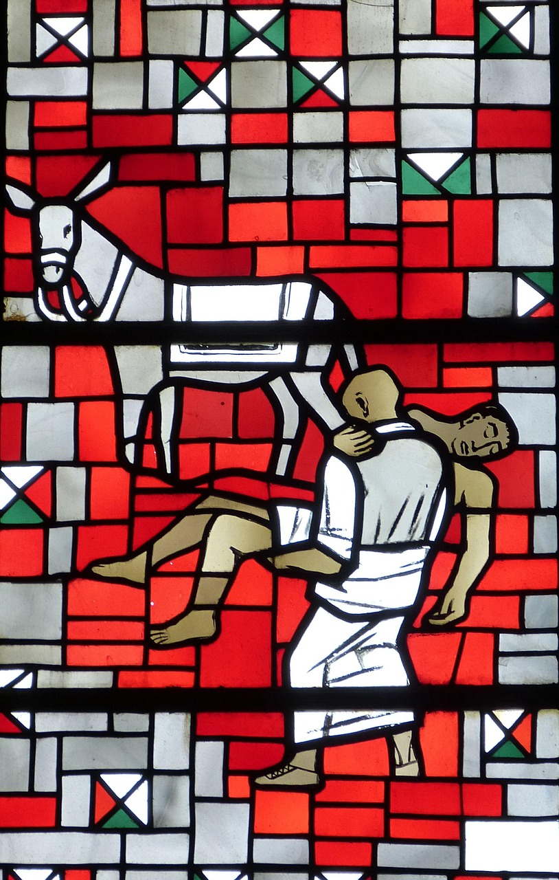 Buntes Kirchenfenster mit der Darstellung eines Mannes, der einen bewusstlosen anderen Mann trägt.